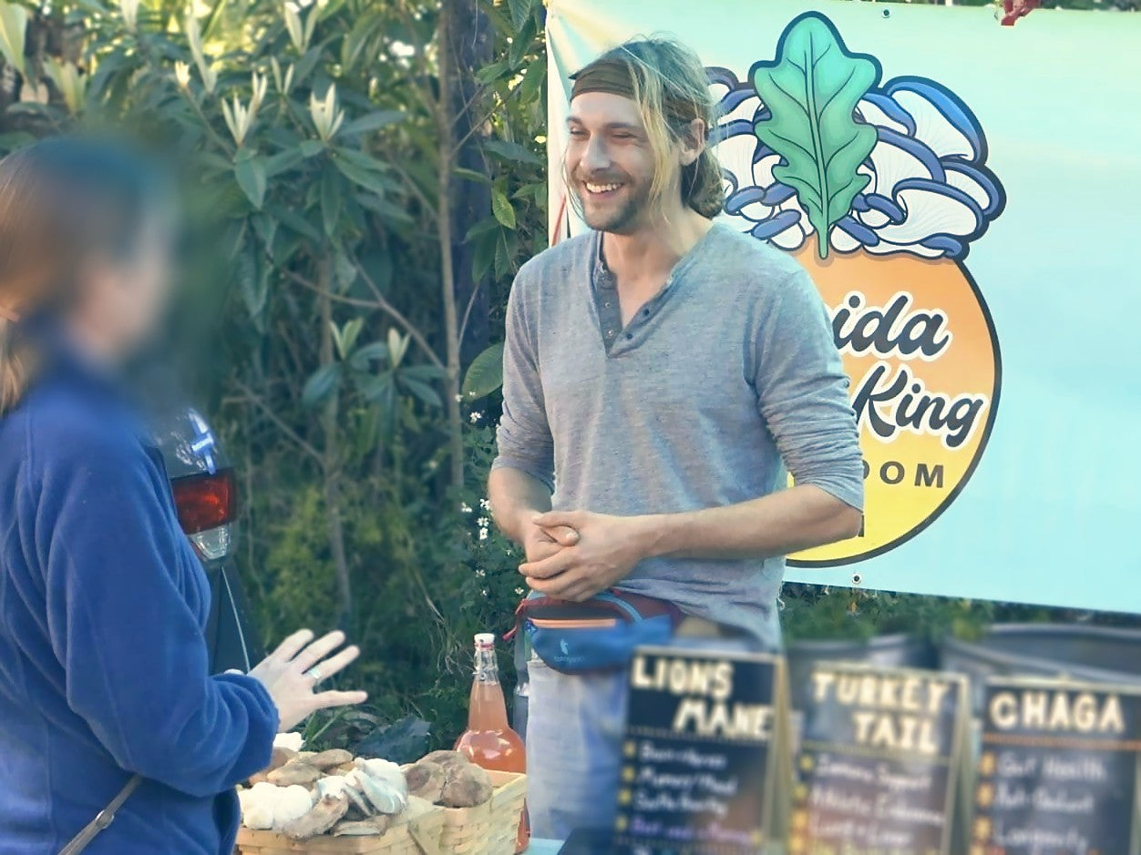 Andrew Johnson talking with a shopper at the Florida Shroom King farmers market booth