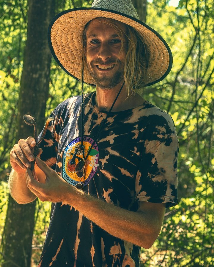 Andrew Johnson holding a small wild mushroom on a Florida Mycological Society foraging walk